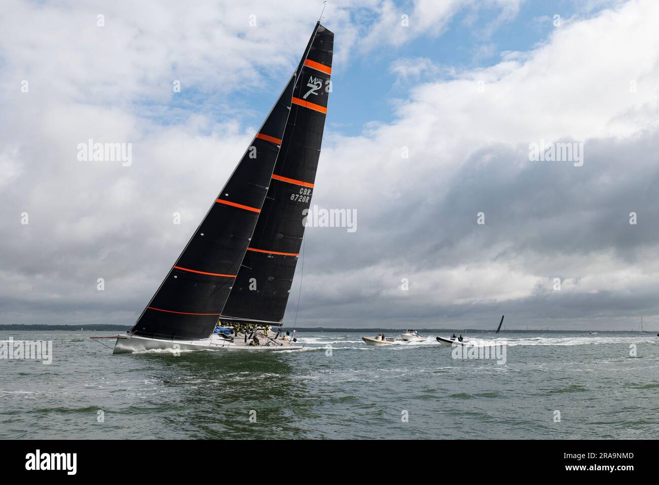 Die berüchtigte Maxi 72 Racing Yacht treibt den Solent mit Verfolgungsbooten auf dem Weg zu einer fantastischen 2.-Position im Round the Island Race an Stockfoto