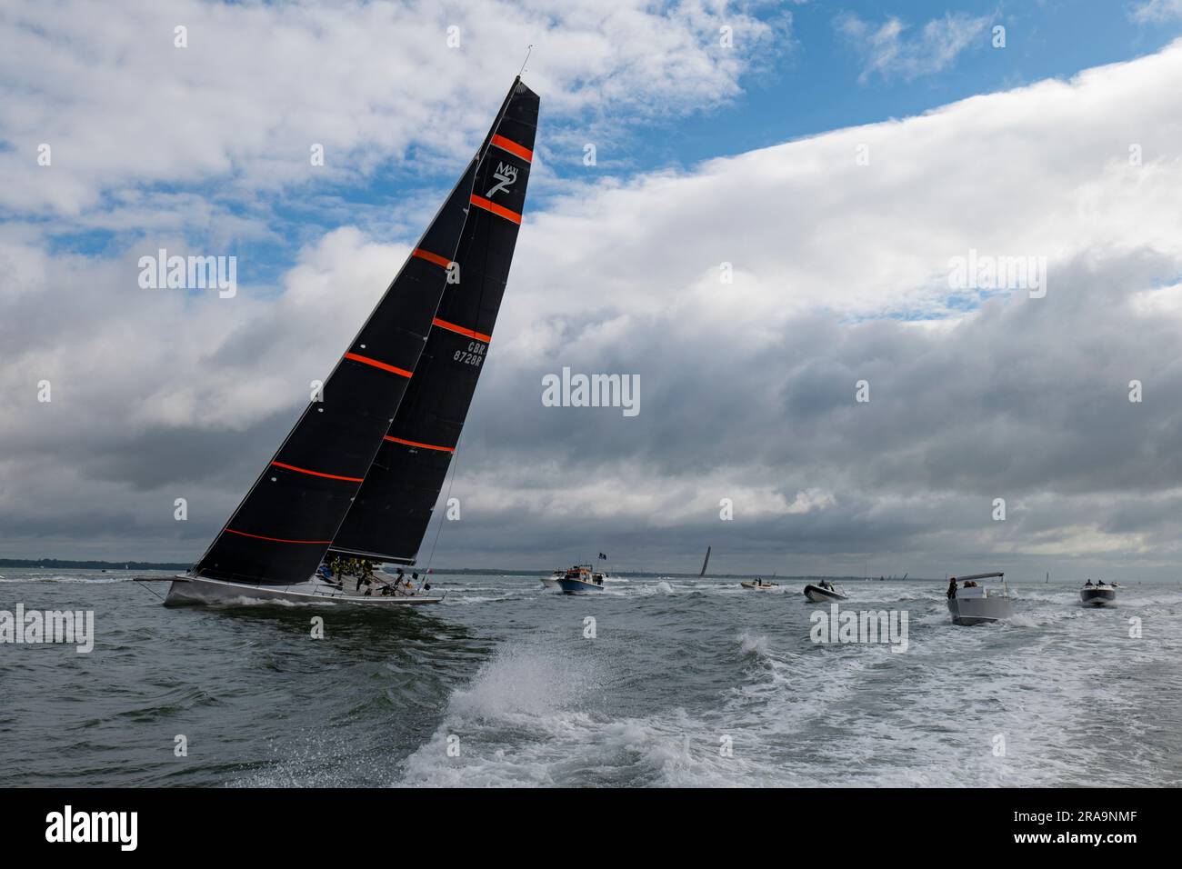 Die berüchtigte Maxi 72 Racing Yacht treibt den Solent mit Verfolgungsbooten auf dem Weg zu einer fantastischen 2.-Position im Round the Island Race an Stockfoto