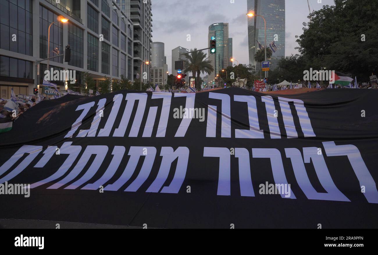 TEL AVIV, ISRAEL - JULI 1: Israelische Friedensaktivisten halten ein großes Banner, auf dem steht: "Es ist zwingend notwendig, sich dem Siedlerterrorismus zu widersetzen", während sich regierungsfeindliche Demonstranten während einer Massendemonstration gegen 26. Ministerpräsident Benjamin Netanjahu und Israels Plan des rechtskräftigen Justizsystems versammeln, der darauf abzielt, den Obersten Gerichtshof des Landes zu schwächen 1. Juli 2023 in Tel Aviv, Israel. Seit dem 7. Januar gibt es Proteste gegen die rechtsgerichtete Koalition Israels und die von ihr vorgeschlagenen gerichtlichen Änderungen. Kredit: Eddie Gerald/Alamy Live News Stockfoto