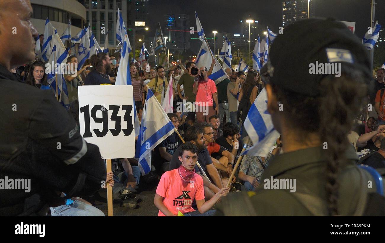 TEL AVIV, ISRAEL - JULI 1: Regierungsfeindliche Demonstranten halten ein Schild mit der Nummer 1933; In dem Jahr, in dem Hitler an die Macht kam, blockierten sie während einer Demonstration gegen Premierminister Benjamin Netanjahu in der 26. Woche in Folge einen großen Highway und Israels Plan des rechtskräftigen Justizsystems, der darauf abzielt, den Obersten Gerichtshof des Landes am 1. Juli 2023 in Tel Aviv, Israel, zu schwächen. Seit dem 7. Januar gibt es Proteste gegen die rechtsgerichtete Koalition Israels und die von ihr vorgeschlagenen gerichtlichen Änderungen. Kredit: Eddie Gerald/Alamy Live News Stockfoto