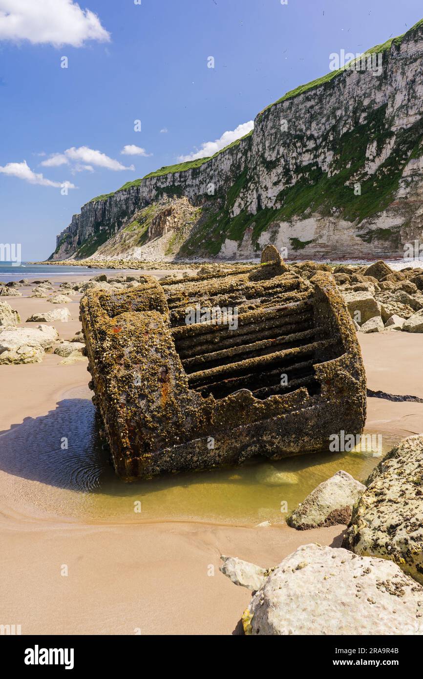 Verrostete alte Schiffskessel am Fuße der Kreideklippen am Ende von Speeton Sands in Filey Bay. Unter den Felsen am Fuße der Klippen ist dies Stockfoto