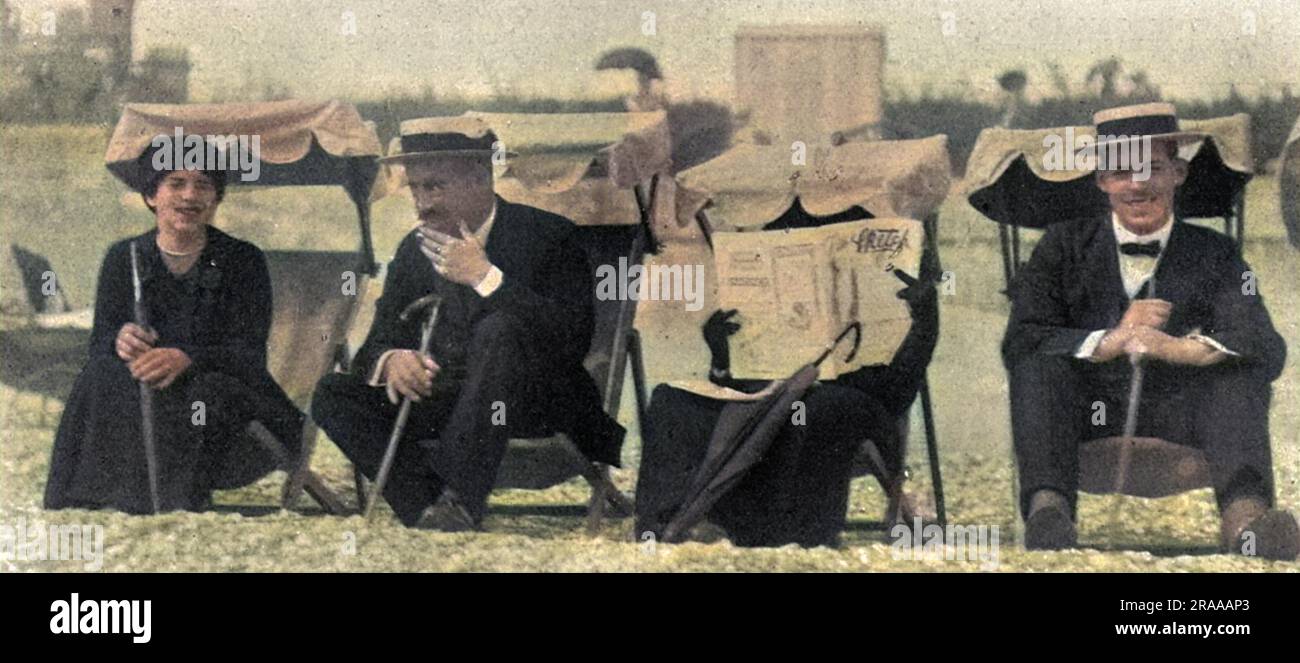 Die Königin von Griechenland, früher Prinzessin Sophie von Preußen, versteckt sich vor einem Fotografen am Strand von Eastbourne mit einer Kopie des Sketch Magazins. Entweder das, oder sie findet das Magazin total absorbierend. Das Bild zeigt von links Prinzessin Helen, König Konstantin von Griechenland, Königin Sophie von Griechenland und Prinz Alexander (später König Alexander von Griechenland). Datum: 1913 Stockfoto