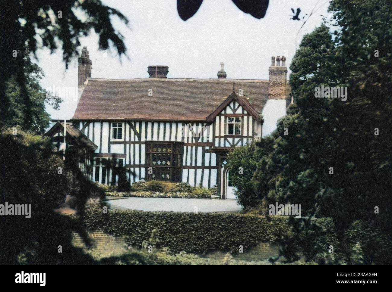 Blick auf das alte Pfarrhaus, ein denkmalgeschütztes Gebäude der Kategorie I im Dorf Gawsworth, Cheshire. Es stammt aus dem 15. Oder 16. Jahrhundert und ist aus Holz gerahmt. Es gab Berichte über paranormale Aktivitäten. Datum: 20. Jahrhundert Stockfoto