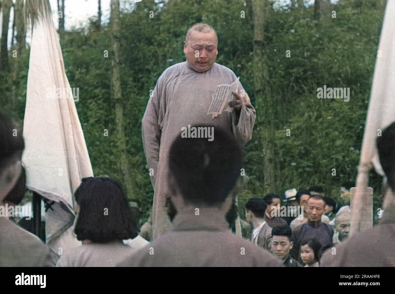 Bei einem antikommunistischen Treffen in Wukiang, bei dem junge Menschen und Studenten zusammentreffen, hält der örtliche Richter, der das traditionelle lange Kleid trägt, eine Rede. Datum: 1939 Stockfoto