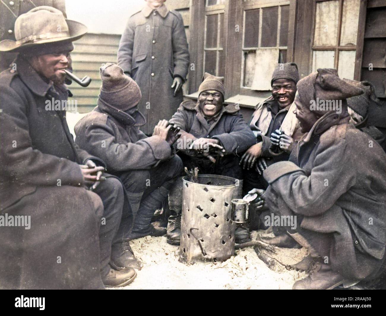 Schwarze Soldaten, die sich während des Ersten Weltkriegs in einem Lager in der Nähe der Westfront in Frankreich bei einem Brazier warm hielten. Datum: Ca. 1917 Stockfoto