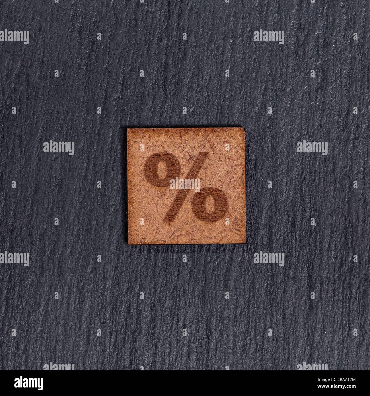 Prozentzeichen In Quadratischen Holzfliesen - Symbol %, Auf Schwarzem Steinhintergrund. Stockfoto