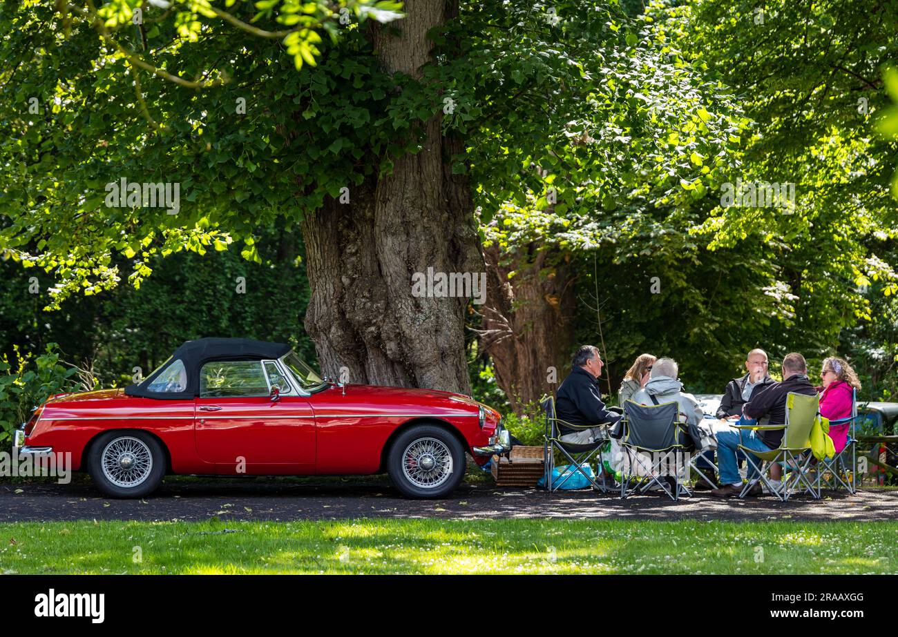 East Lothian, Schottland, Vereinigtes Königreich, 2. Juli 2023. Räder von gestern: Die jährliche Joggingtour der Scottish Association of Vehicles führt Besitzer von Oldtimern durch die Landschaft zu den malerischen Landschaften des Lennoxlove House. Bild: Zeit für ein Mittagessen neben einem alten 1973 MGB Roadster. Kredit: Sally Anderson/Alamy Live News Stockfoto