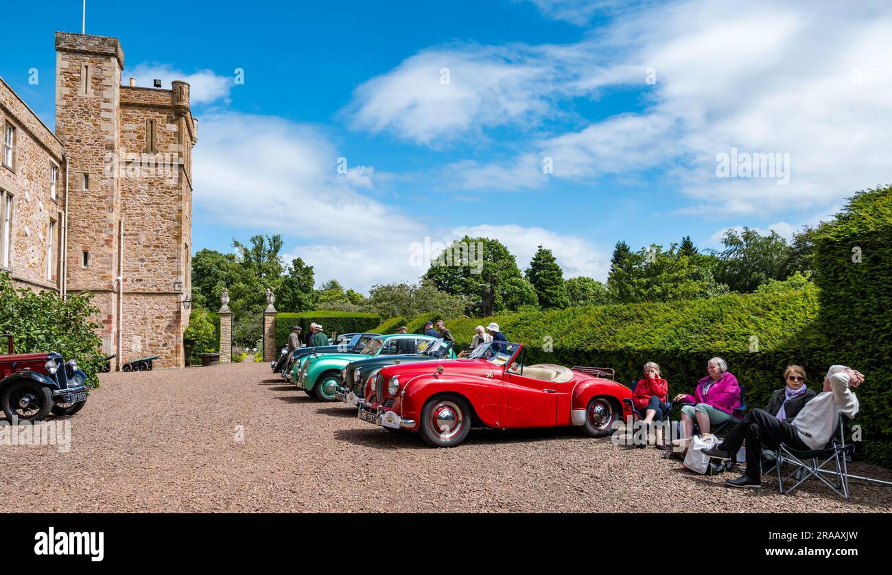 East Lothian, Schottland, Vereinigtes Königreich, 2. Juli 2023. Räder von gestern: Die jährliche Joggingtour der Scottish Association of Vehicles führt Besitzer von Oldtimern durch die Landschaft zu den malerischen Landschaften des Lennoxlove House. Abbildung: Enthusiasten bewundern die alten Autos. Kredit: Sally Anderson/Alamy Live News Stockfoto