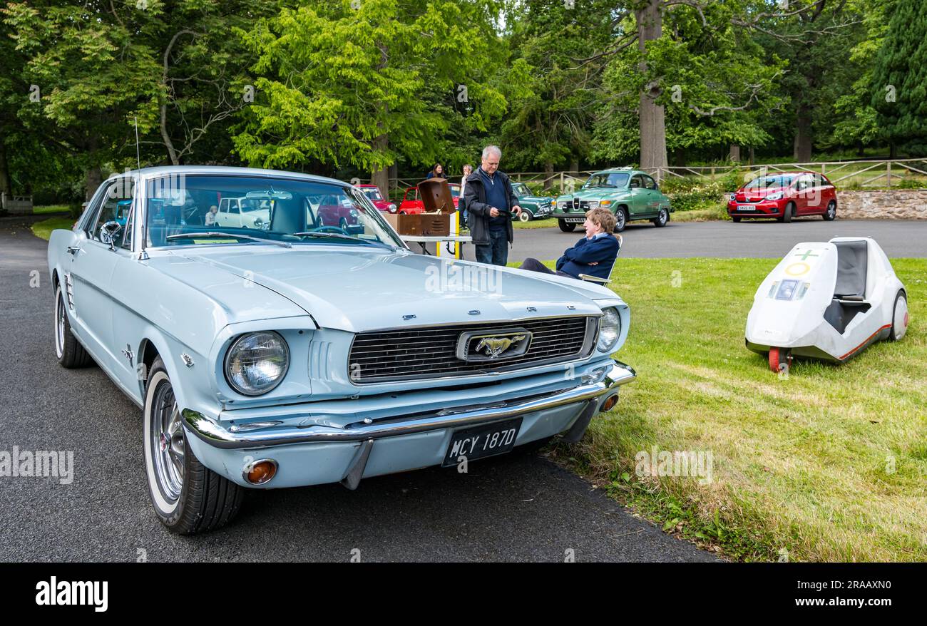 East Lothian, Schottland, Vereinigtes Königreich, 2. Juli 2023. Räder von gestern: Die jährliche Joggingtour der Scottish Association of Vehicles führt Besitzer von Oldtimern durch die Landschaft zu den malerischen Landschaften des Lennoxlove House. Abbildung: Ein alter 1966 Ford Mustang und ein Sinclair C5 Fahrrad. Kredit: Sally Anderson/Alamy Live News Stockfoto
