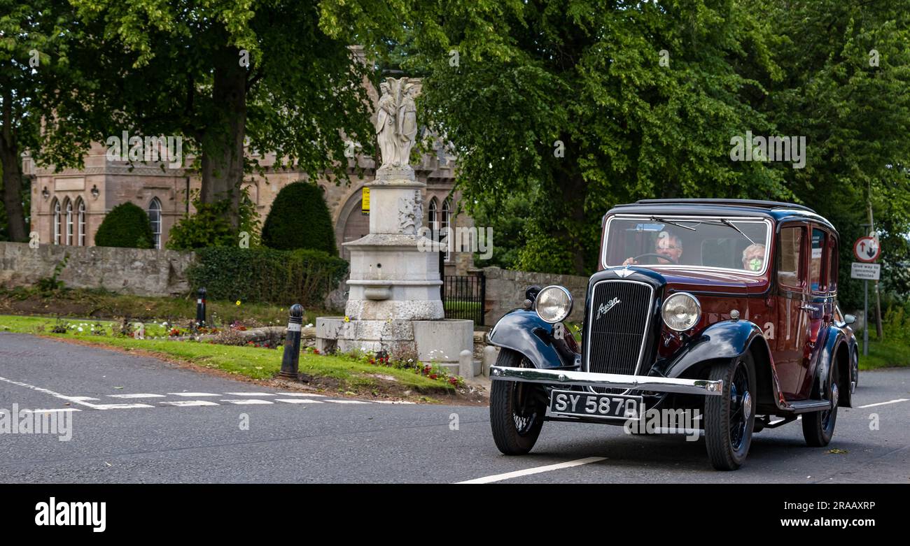 East Lothian, Schottland, Vereinigtes Königreich, 2. Juli 2023. Räder von gestern: Die jährliche Joggingtour der Scottish Association of Vehicle Enthusiasts führt Besitzer von Oldtimern durch die Landschaft. Abbildung: Ein altes Auto aus dem Jahr 1936 in Austin Ascot fährt durch das Dorf East Saltoun. Kredit: Sally Anderson/Alamy Live News Stockfoto