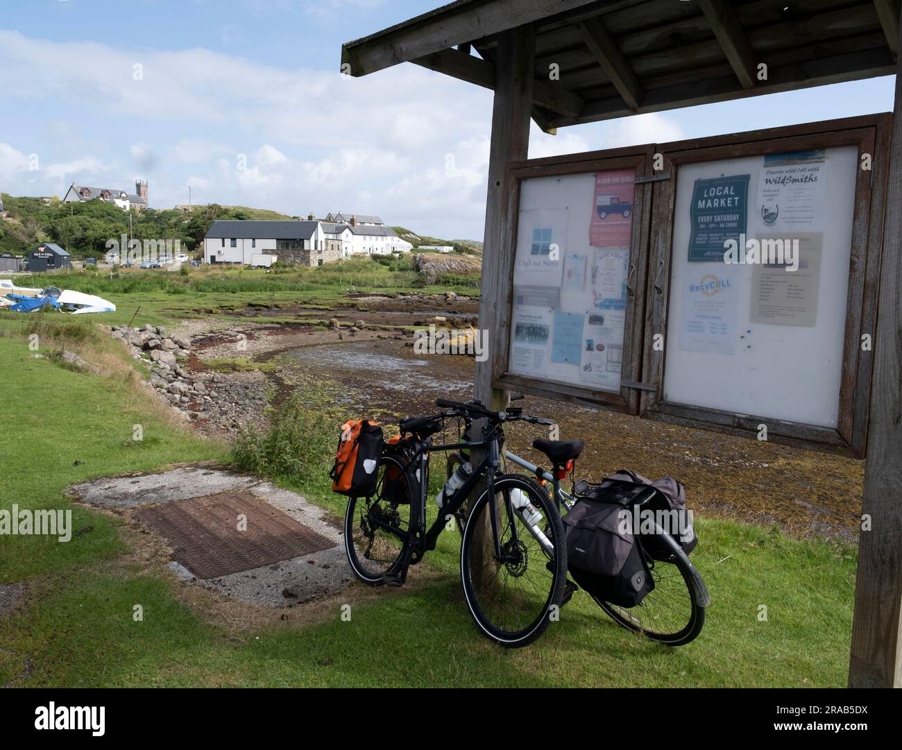 Fahrräder, die sich gegen ein Hinweisschild im Dorf Arinagour, Insel Coll, Innenhebriden, Schottland lehnen Stockfoto