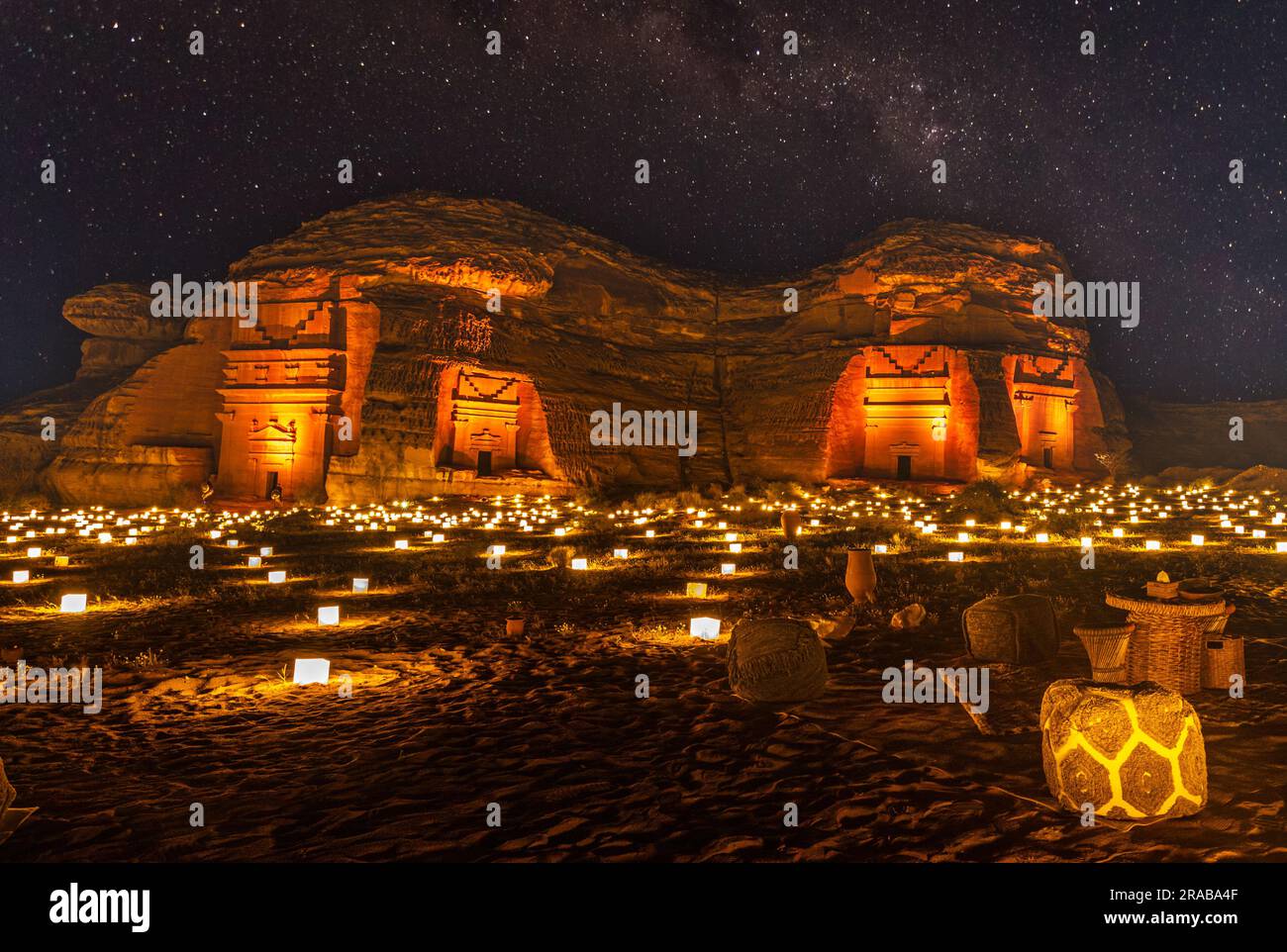 Sternenlicht über den antiken nabatäischen Gräbern der beleuchteten Stadt Hegra, Nachtpanorama, Al Ula, Saudi-Arabien Stockfoto