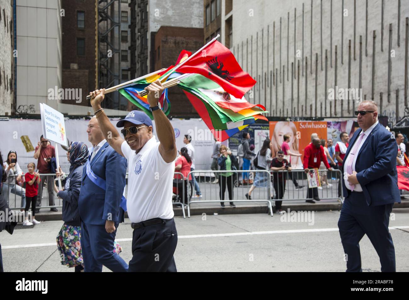 Bürgermeister Eric Adams marschiert in der Immigranten-Parade mit einer Vielzahl internationaler Flaggen, die verschiedene Einwanderergemeinschaften repräsentieren, die Teil des Gefüges sind, aus dem New York City besteht. Stockfoto