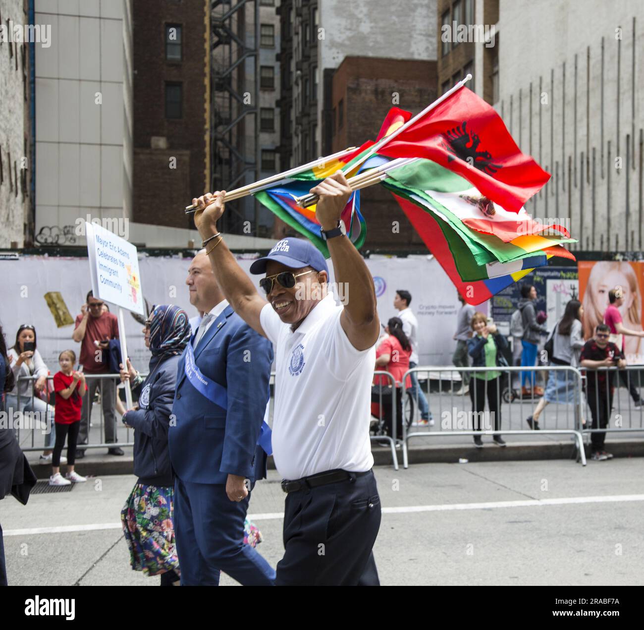 Bürgermeister Eric Adams marschiert in der Immigranten-Parade mit einer Vielzahl internationaler Flaggen, die verschiedene Einwanderergemeinschaften repräsentieren, die Teil des Gefüges sind, aus dem New York City besteht. Stockfoto