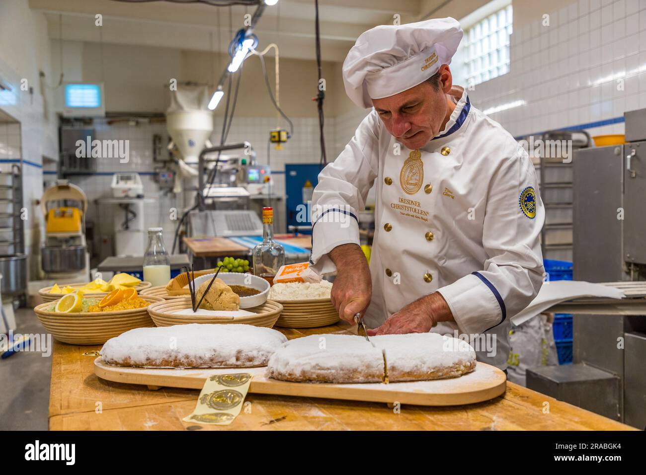 Herstellung eines Dresdner Christstollens in Dresden. Bckermeister Tino  Gierig schneidet einen Dresdner Christstollen. Stollen werden immer in der  Mitte geschnitten, sodass Sie die beiden Hlften zur Aufbewahrung wieder  zusammenschieben knnen und die
