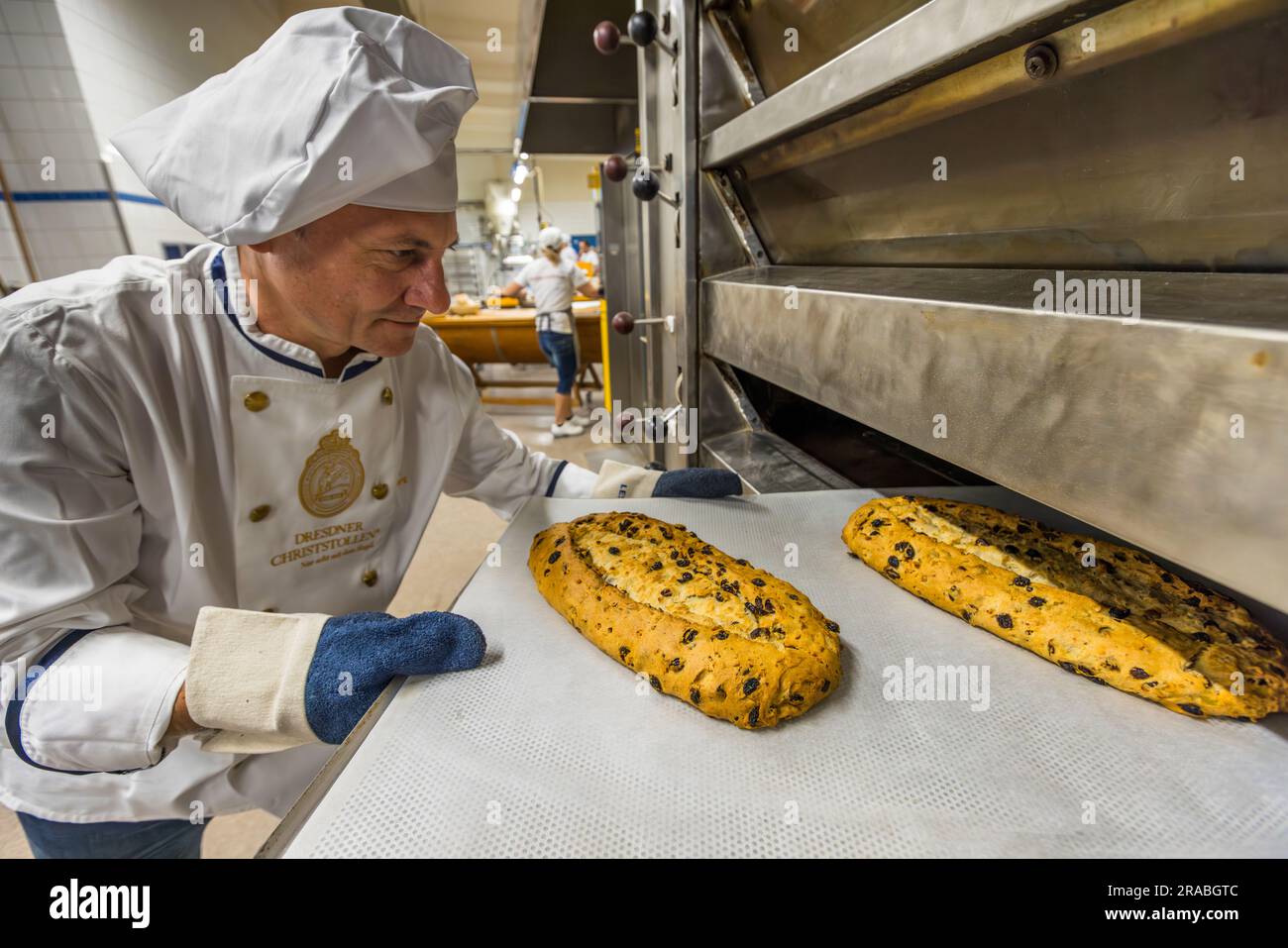 Herstellung eines Dresdner Christstollens in Dresden. Bäckermeister Tino Gierig vom Schutzverband Dresdner Stollen nimmt den Stollen nach 60 Minuten Backzeit aus dem Ofen Stockfoto