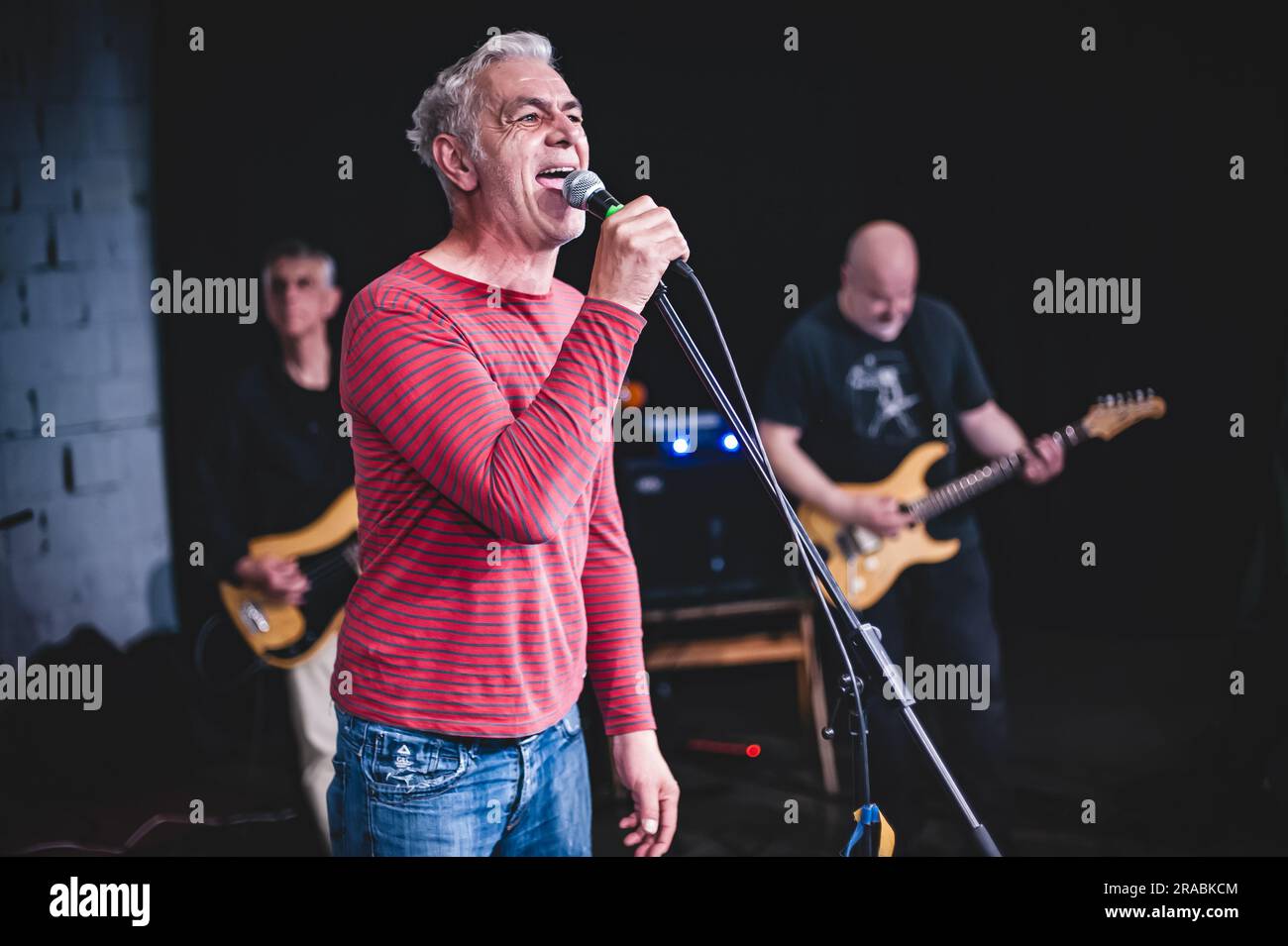 Der Sänger, der Künstler ist, nimmt während einer Live-Aufführung auf einer Bühne ein Porträt auf. Punk-Rock-Musikband-Gruppe Stockfoto