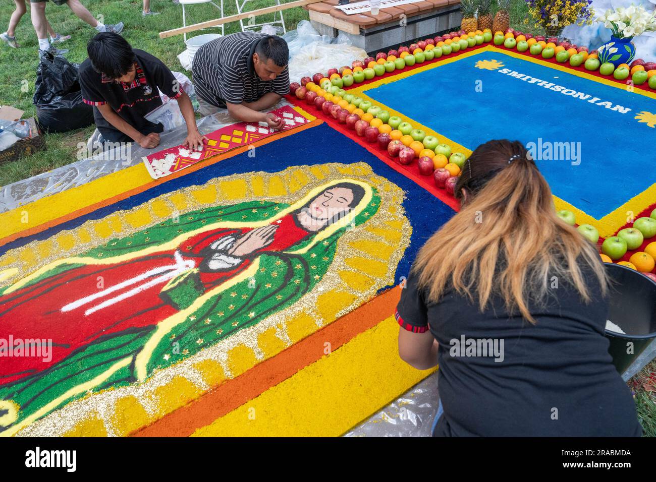 Washington, Usa. 02. Juli 2023. Kevin Cabrera, Armando Hernandez und Roxanna Lopez ergänzen ein Kunstwerk von Lady Mary und Jesus beim Smithsonian Folklife Festival in der National Mall in Washington, DC am Sonntag, den 2. Juli 2023. Foto: Ken Cedeno/UPI Credit: UPI/Alamy Live News Stockfoto