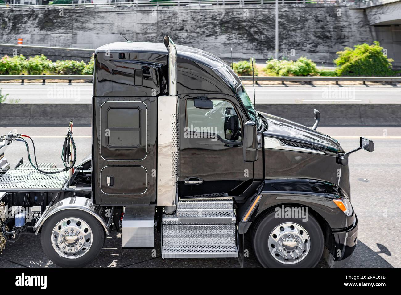 Industrieller professioneller schwarzer langer Transporter großer Lkw mit verlängerter Fahrerkabine für Lkw-Fahrer, der gewerbliche Fracht auf Auflieger dri transportiert Stockfoto