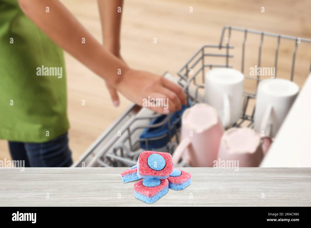 Geschirrspülmitteltabletten auf Holztisch in der Küche, selektiver Fokus Stockfoto