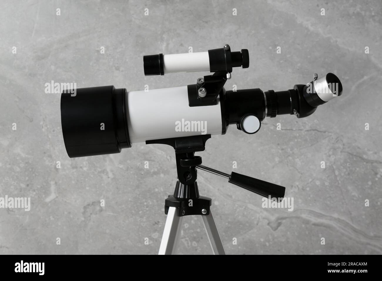 Stativ mit modernem Teleskop nahe der grauen Wand, Nahaufnahme Stockfoto
