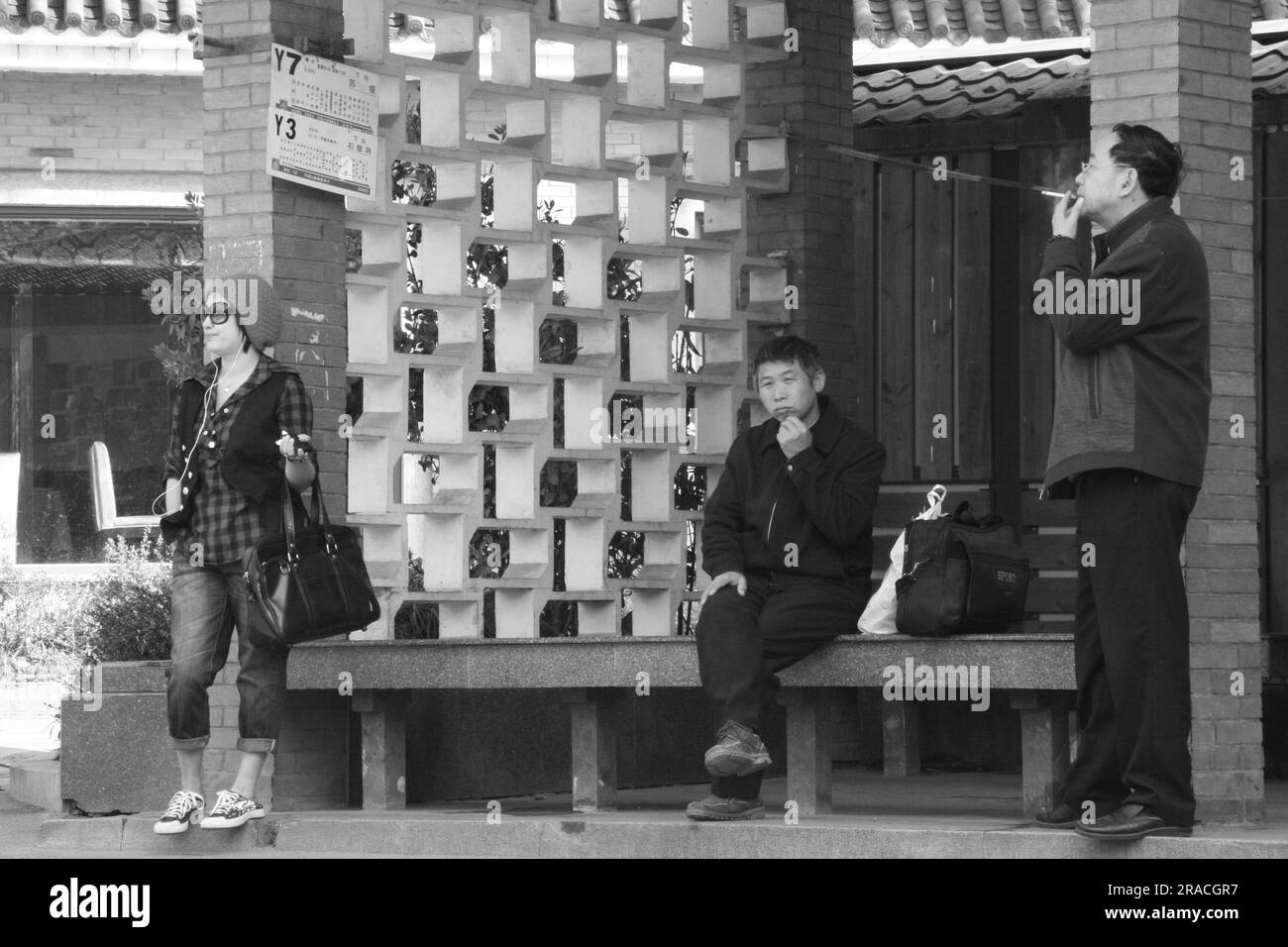Drei Persönlichkeiten warten auf den Bus in Hangzhou China Stockfoto