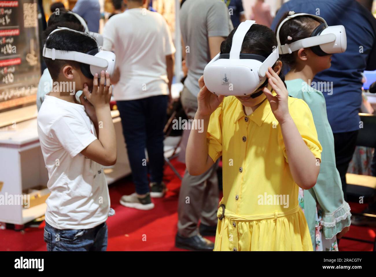 Bagdad, Irak. 2. Juli 2023. Kinder testen Virtual-Reality-Headsets (VR) während der zweiten Ausgabe des International Festival for Iraqi Children auf der Bagdad International Fair in Bagdad, Irak, am 2. Juli 2023. Das zehntägige Festival dauert bis zum 3. Juli. Kredit: Khalil Dawood/Xinhua/Alamy Live News Stockfoto