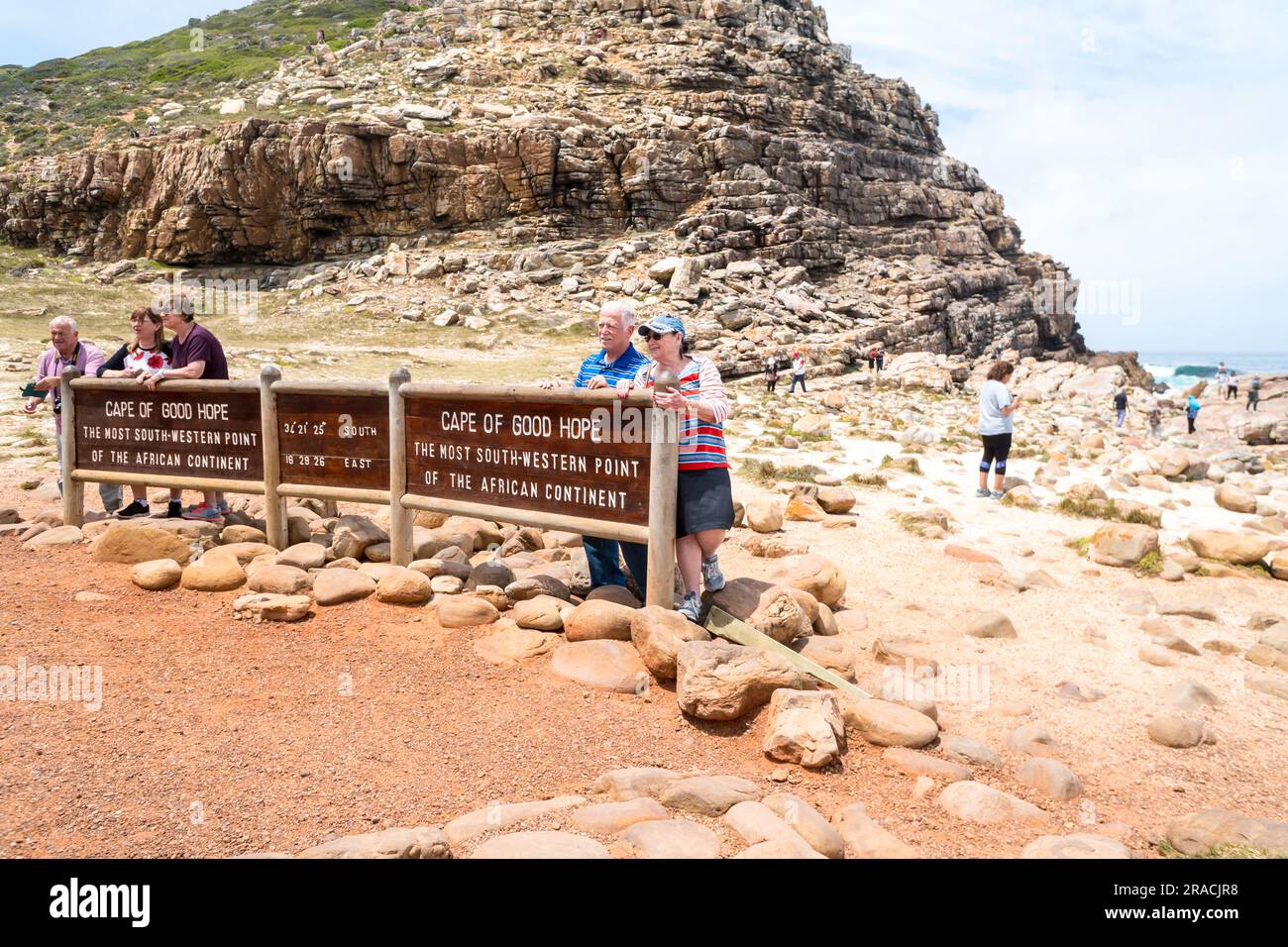 Schild oder Beschilderung zum Kap der Guten Hoffnung mit Touristen, Menschen, die Fotos als Andenken, Souvenirs, Erinnerungen an der südwestlichen Spitze des afrikanischen Kontinents machen lassen Stockfoto