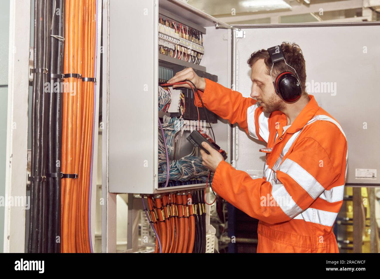 Fehlersuche durch Elektriker in der Schalttafel im Maschinenraum. Junge Fachleute der Öl- und Gasindustrie. Stockfoto