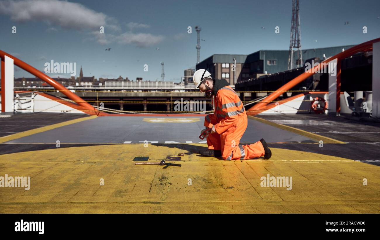 Ein Schiffsingenieur, der den Tank für Heizöl auf dem Frachtdeck des Versorgungsschiffs im Hafen ausruht. Stockfoto