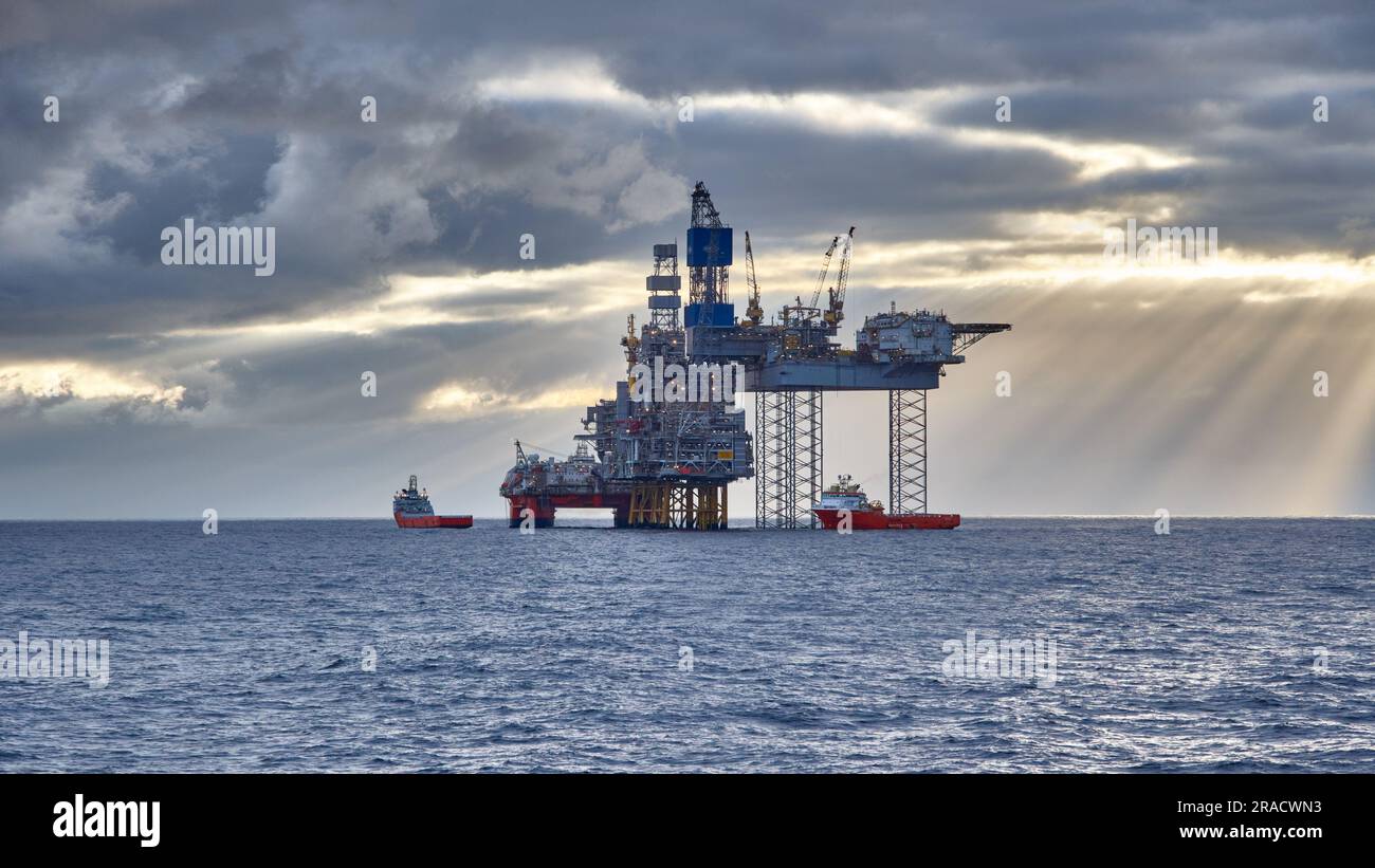 Erdöl- und Erdgasindustrie in der Nordsee. Ansicht der Aufbockbohrer-Bohrplattform mit Versorgungsschiffen im Meer. Stockfoto