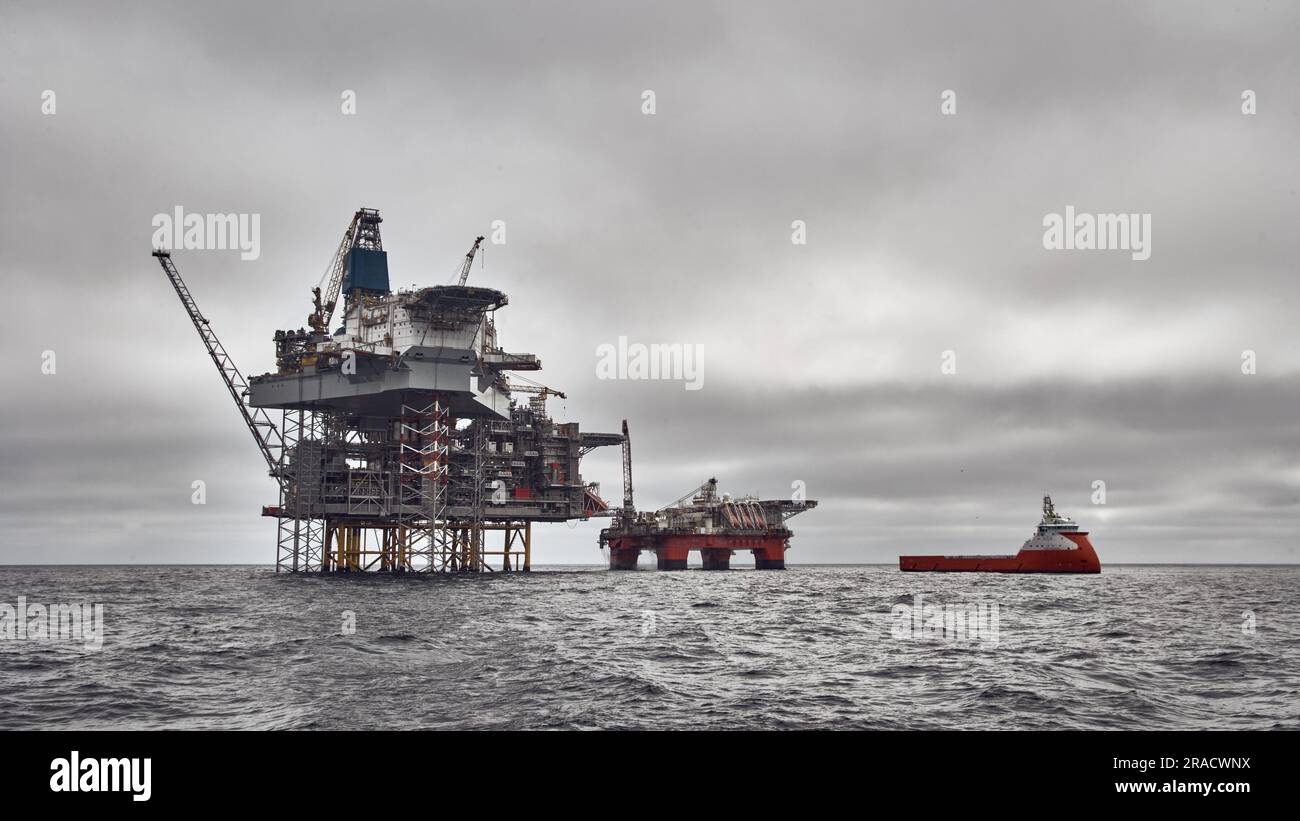 Panoramablick auf die Bohrinsel Jack Up, die halbtauchfähige Plattform und das Versorgungsschiff an einem dunklen bewölkten Tag im Meer. Nordsee-Öl und -Gas. Stockfoto