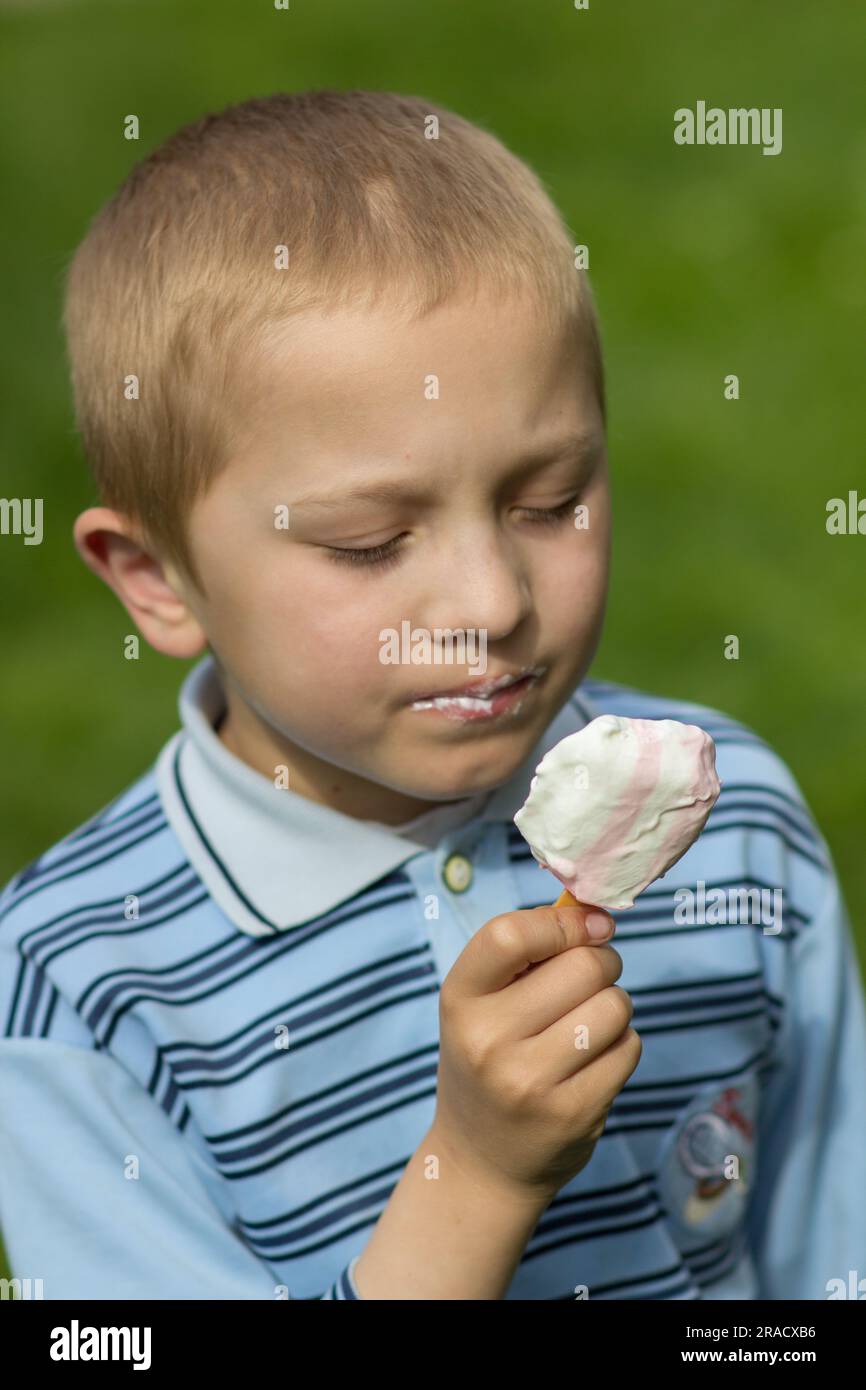 Der Junge kann kein Eis essen, Eis in den Händen des Jungen Stockfoto