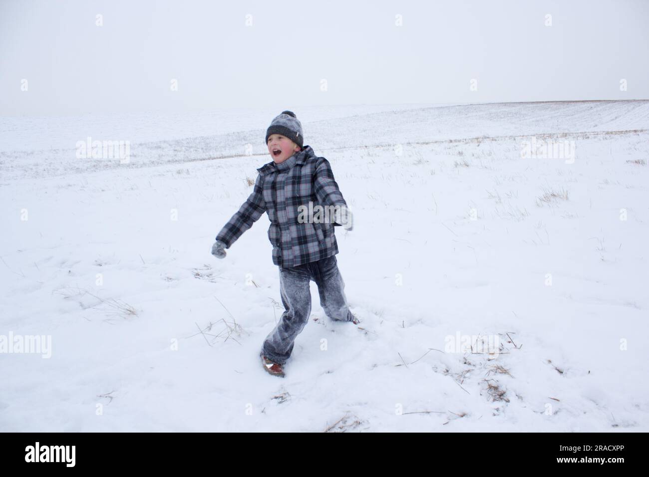 Im Winter spielt der Junge mit Schnee, der Junge ist im Schnee Stockfoto