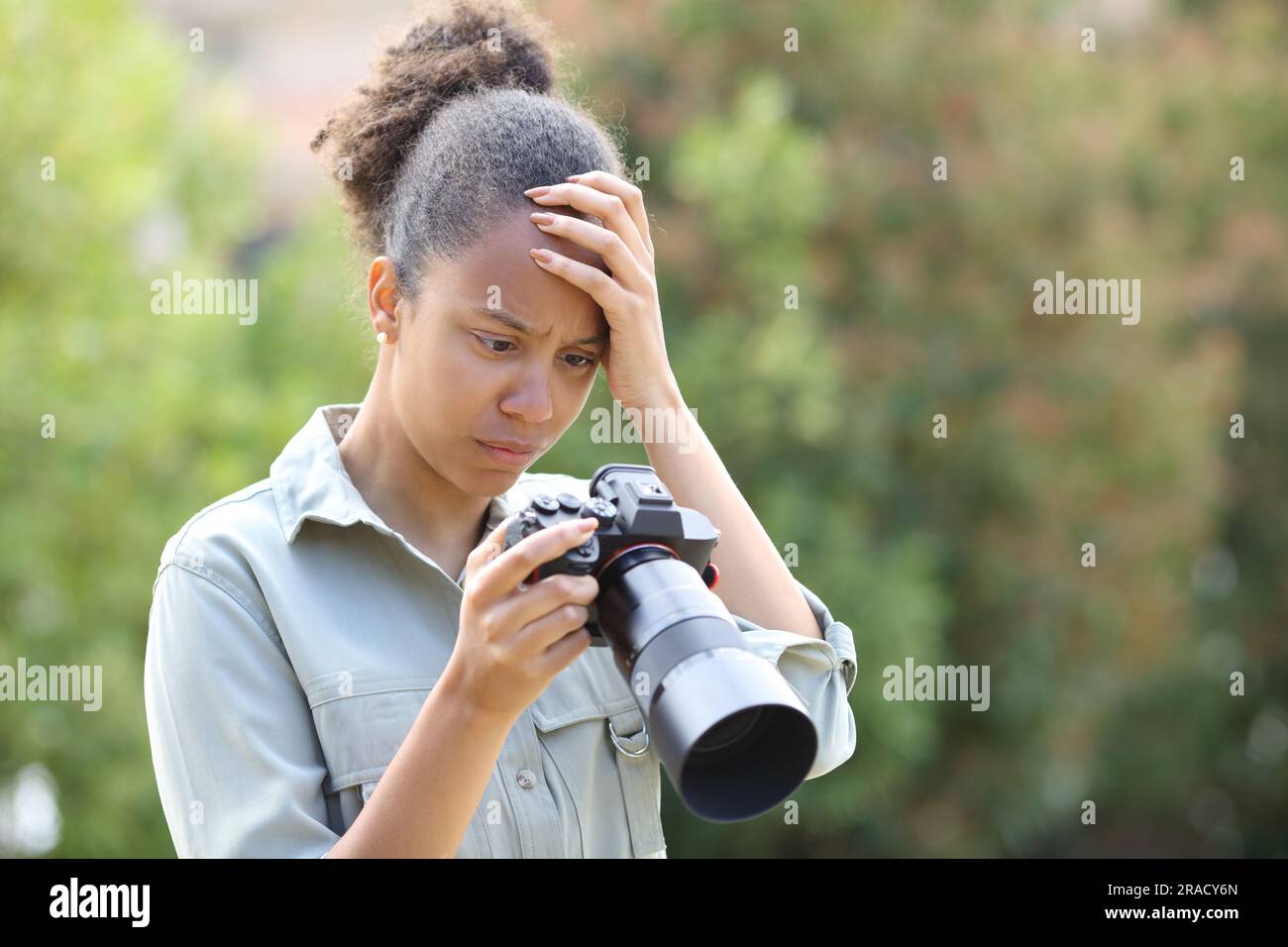 Ein schwarzer Fotograf beschwert sich über die Fotos auf der Kamera in einem Park Stockfoto