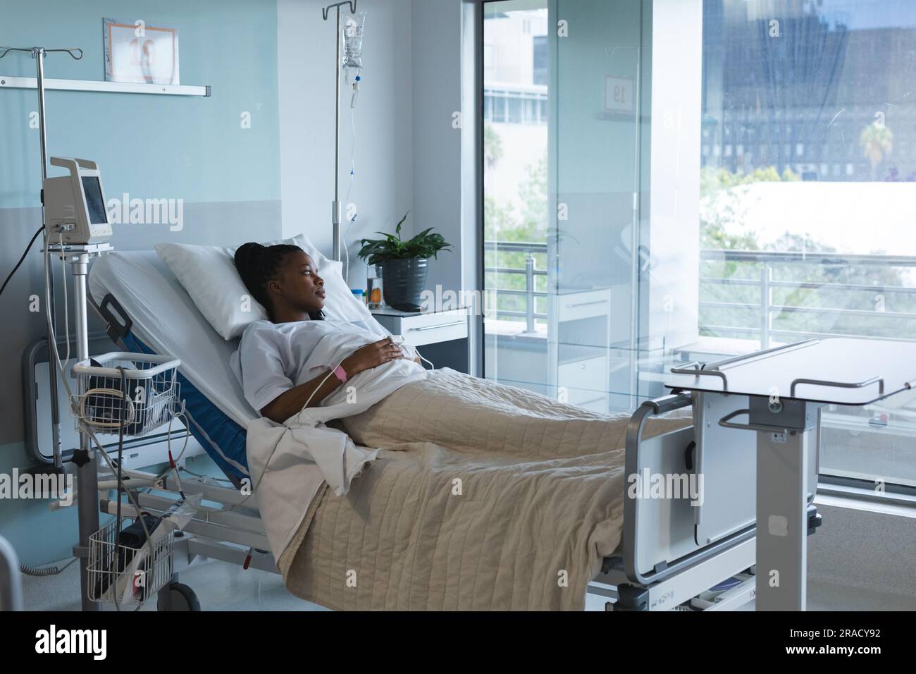 afroamerikanische Patientin blickt weg, liegt auf dem Bett im Krankenhauszimmer. Krankenhaus, Medizin und Gesundheitswesen, unverändert. Stockfoto