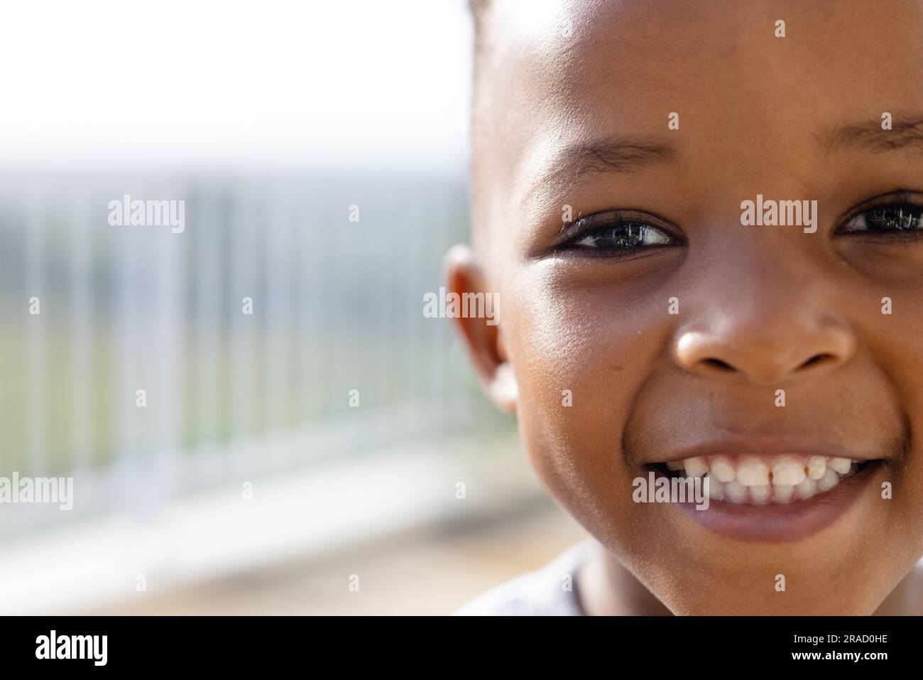 Ein halbes Porträt eines glücklichen afroamerikanischen Jungen auf der sonnigen Terrasse Stockfoto