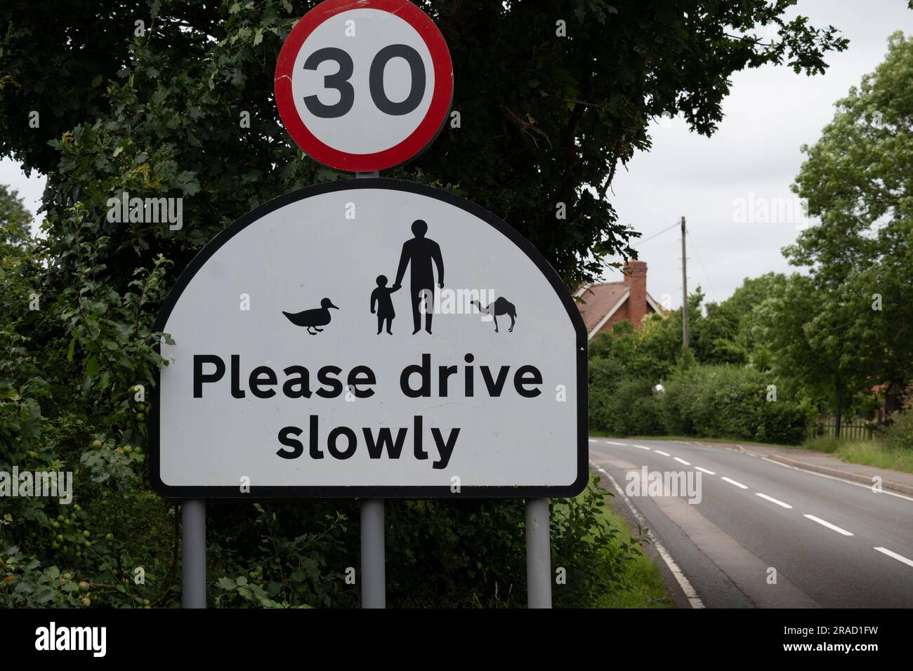 Bitte fahren Sie langsam mit einem Schild mit Camel, Old MIlverton Village, Warwickshire, England, Großbritannien Stockfoto