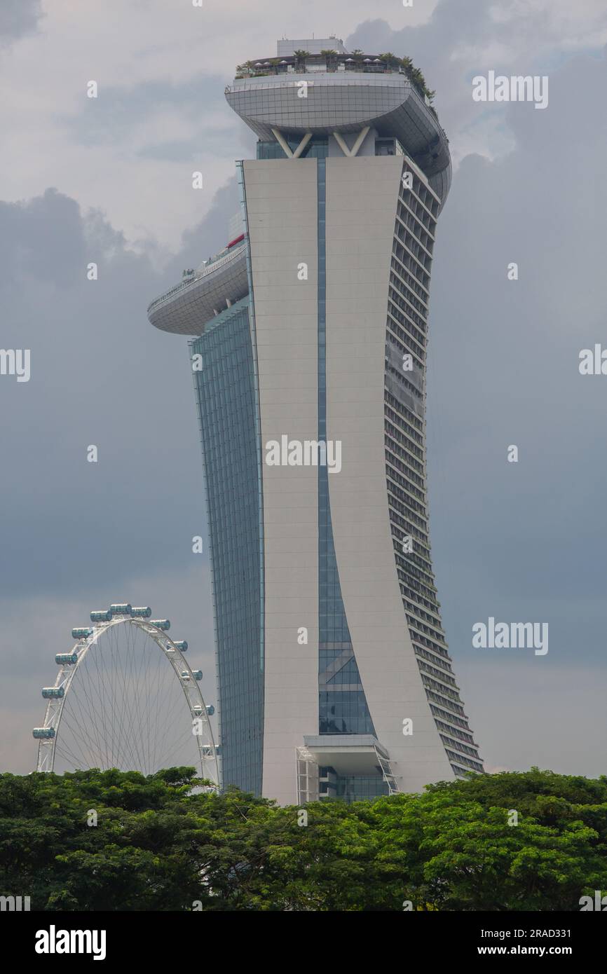 Seitlicher vertikaler Blick auf Marina Bay Sands und Singapore Flyer unter dem trüben bewölkten Wetter. Stockfoto