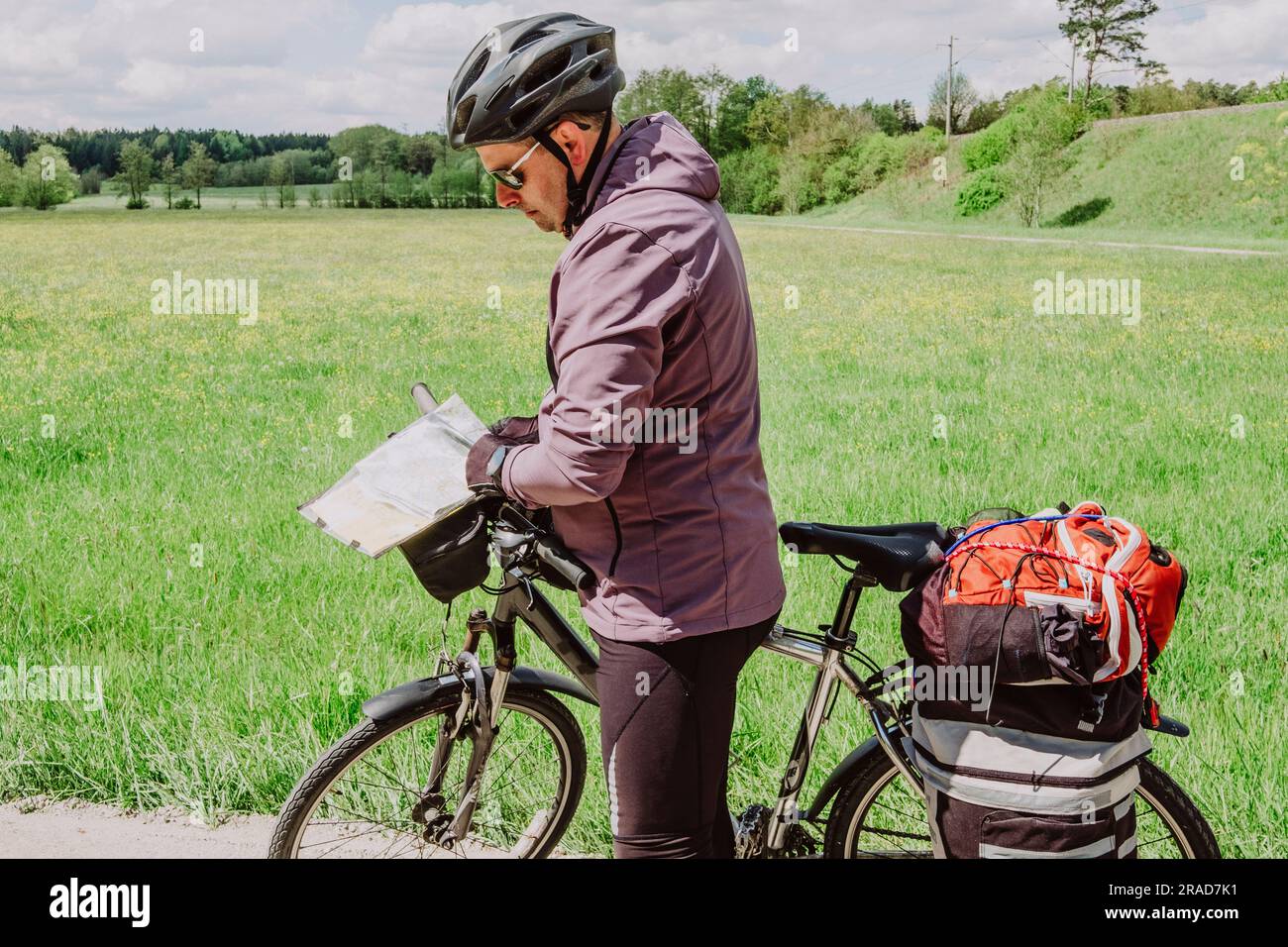 Ein Radfahrer konsultiert eine Karte auf der Reise nach Deutschland Stockfoto
