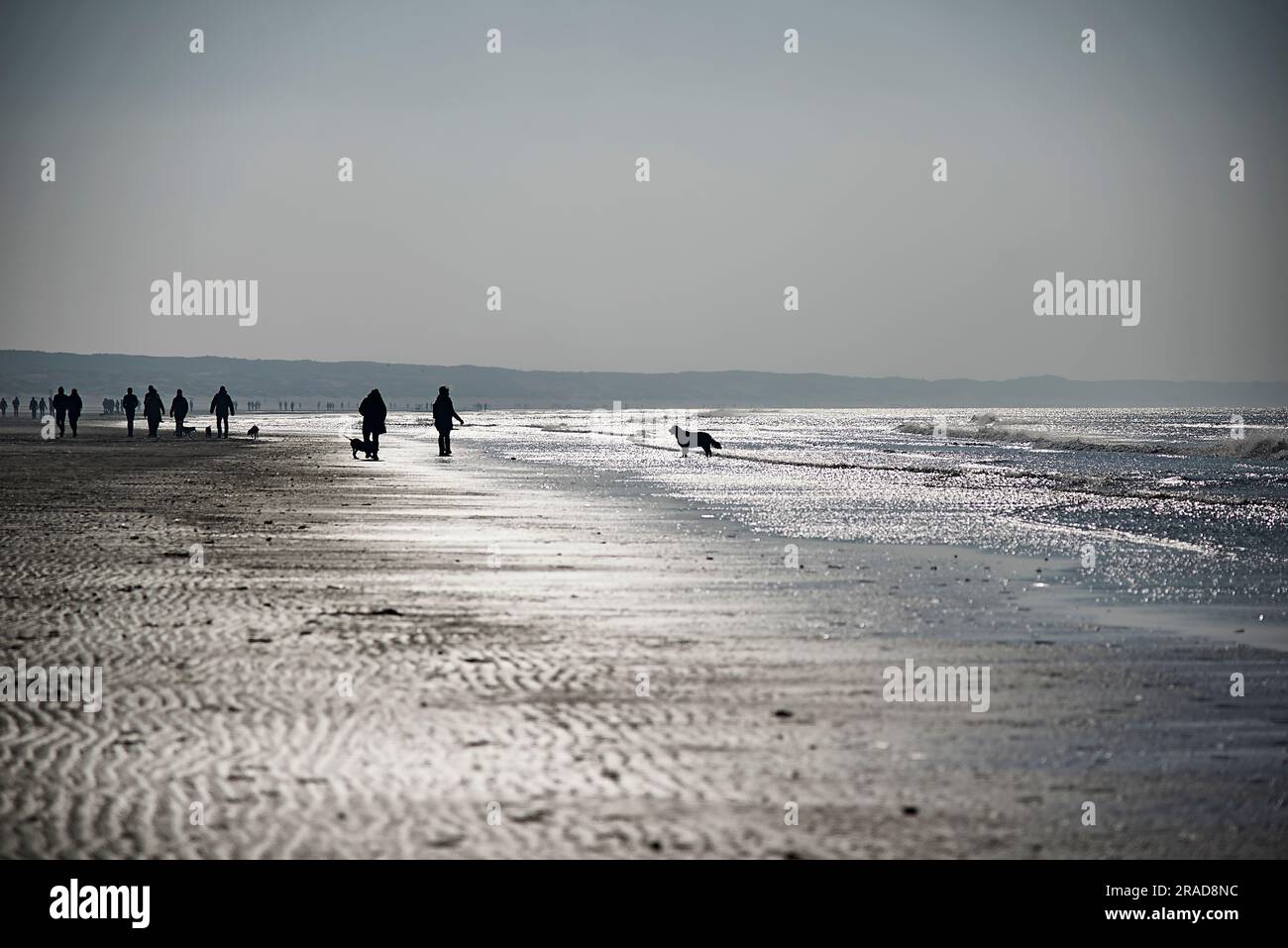 Menschenmassen genießen einen Spaziergang am Strand in der kalten Wintersonne Stockfoto
