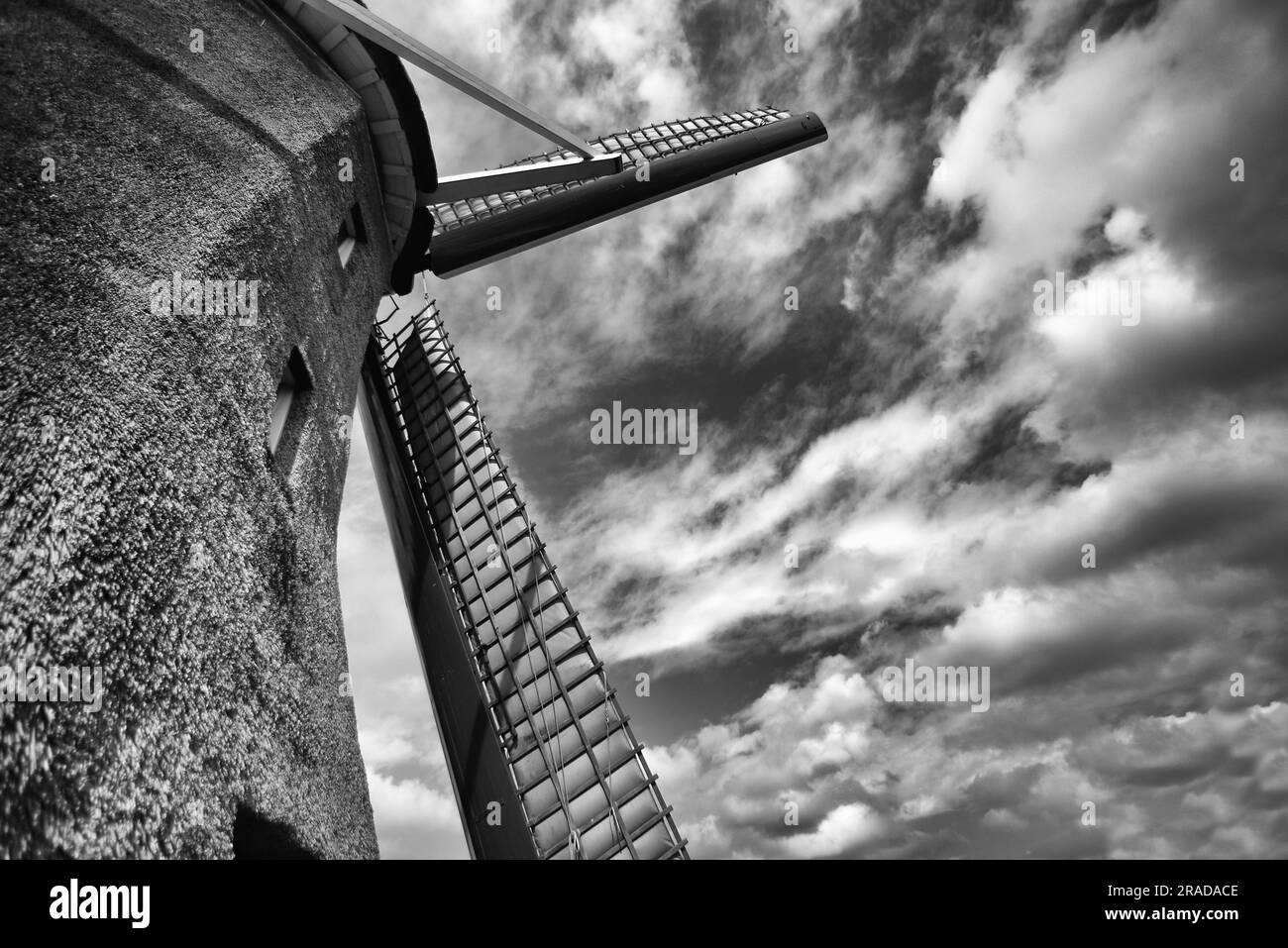 Dramatisches Schwarz-Weiß-Bild einer niederländischen Windmühle mit bewölktem Himmel Stockfoto