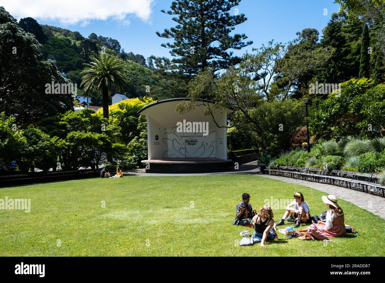 Eine Gruppe junger Freunde picknickt gemeinsam im Freilichttheater im Wellington Botanic Garden auf Kelburn Hill, Wellington, Neuseeland Stockfoto
