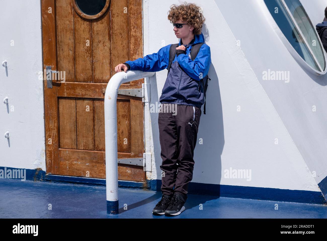 Teenager Tourist mit sehr lockigen Haaren und Schatten auf Wellington nach Picton Cook Strait Ferry Crossing von Nordinsel nach Südinsel, Neuseeland Stockfoto