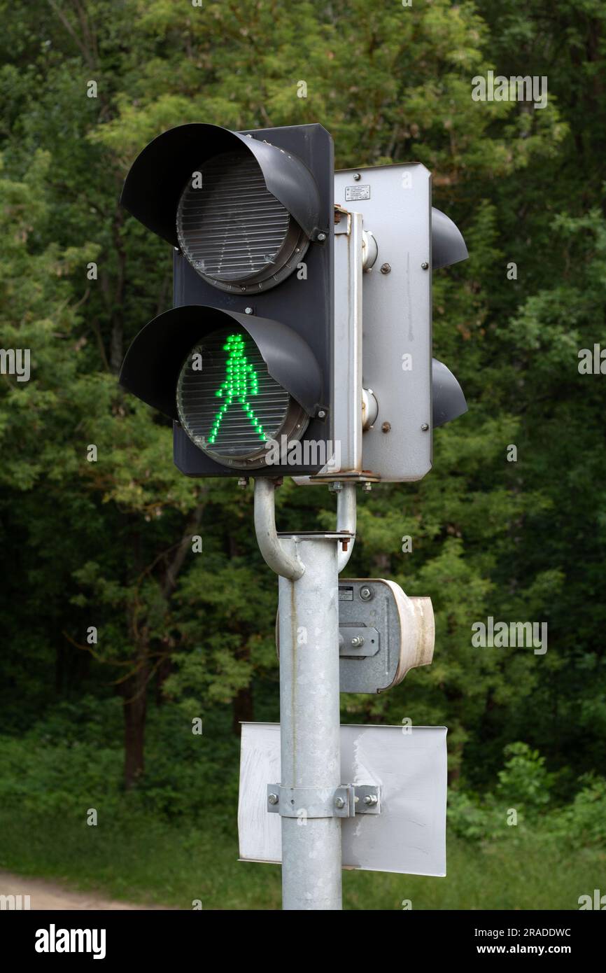 Die Ampel für den Fotoverkehr ist grün und im Hintergrund befinden sich Bäume Stockfoto