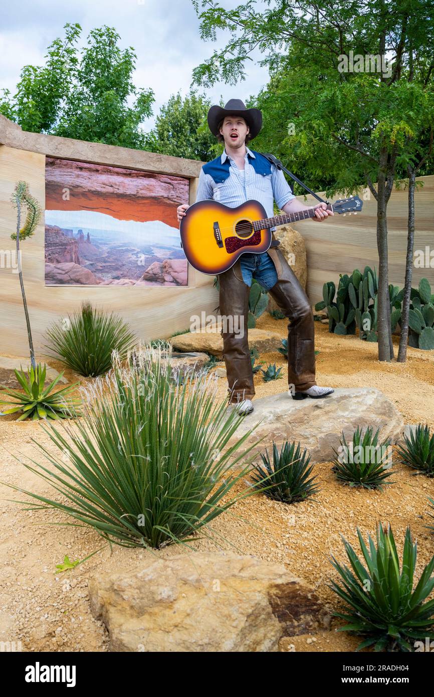 London, Großbritannien. 3. Juli 2023 Ein Schauspieler des West End Musicals „Oklahoma“ tritt im „America's Wild“-Garten auf, präsentiert von Trailfinders and Visit the USA bei der Pressevorschau beim RHS Hampton Court Palace Garden Festival. Die weltweit größte Blumenshow umfasst Gärten von inspirierenden Designern, Vorträge von Prominenten, Vorführungen und Workshops. Kredit: Stephen Chung / Alamy Live News Stockfoto