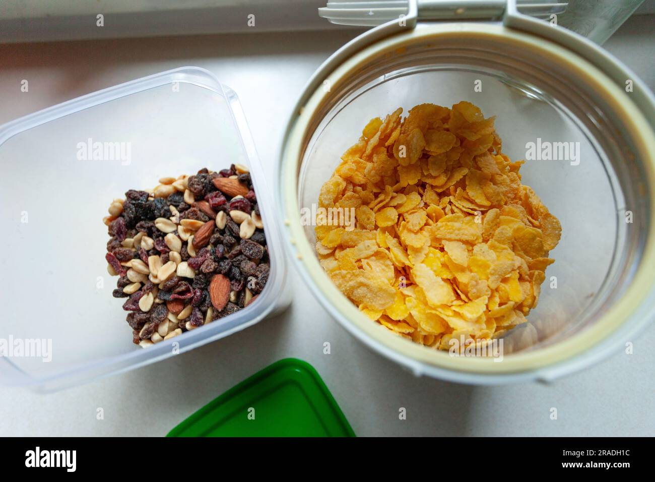 Delikatessen und Cornflakes in Plastikbehältern stehen auf der Küchentheke, Draufsicht Stockfoto