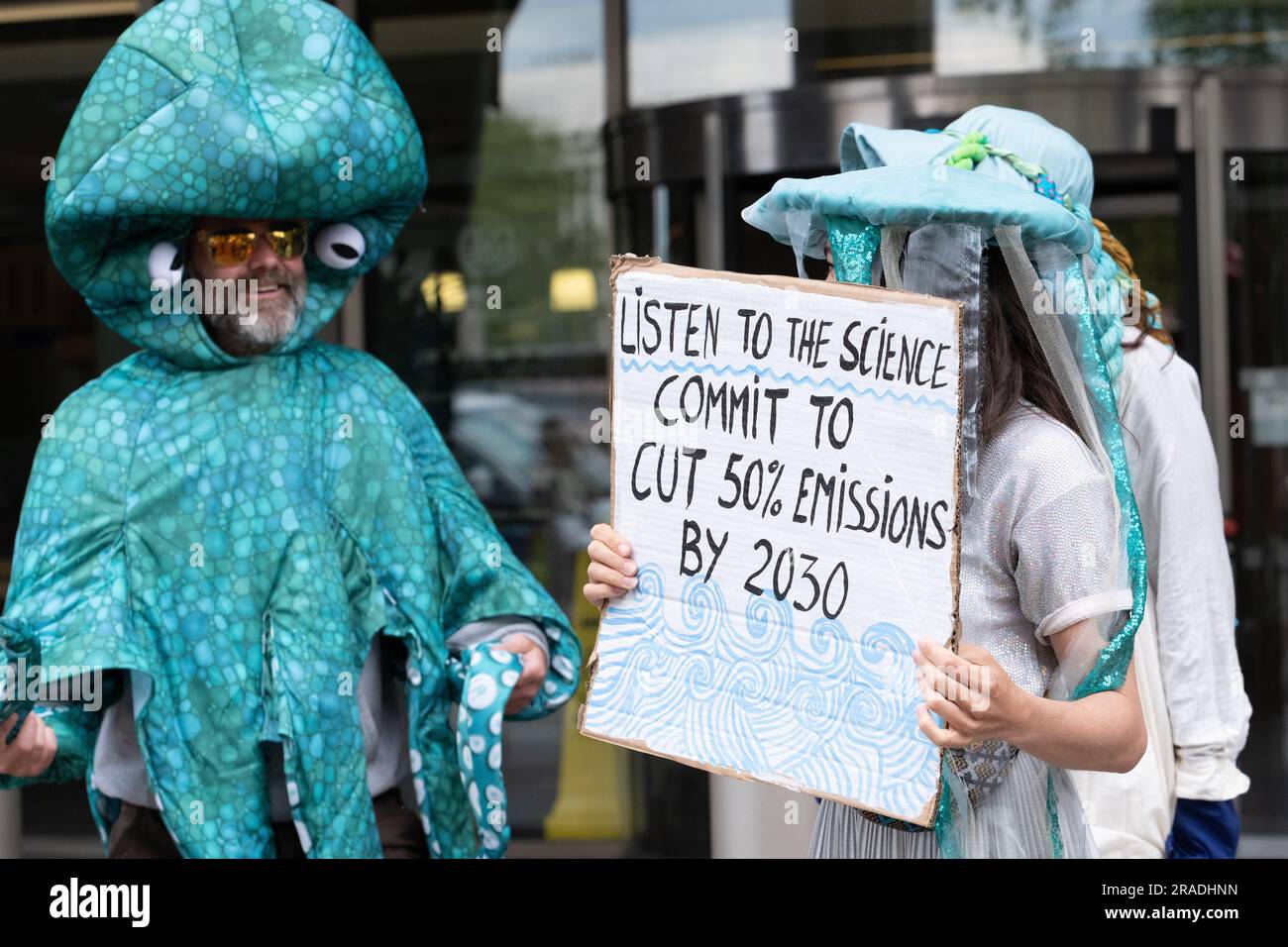 London, Großbritannien. 3. Juli 2023. Aktivisten der "Clean Shipping Coalition" und der "Ocean Rebellion" in aquatischen Kostümen veranstalten einen Protest außerhalb des Hauptquartiers der Internationalen Seeschifffahrtsorganisation (IMO) und fordern eine Verpflichtung zur 50%igen Verringerung der Treibhausgasemissionen des Schifffahrtssektors bis 2030, während die IMO zusammentritt, um die Strategie zu erörtern. Kredit: Ron Fassbender/Alamy Live News Stockfoto