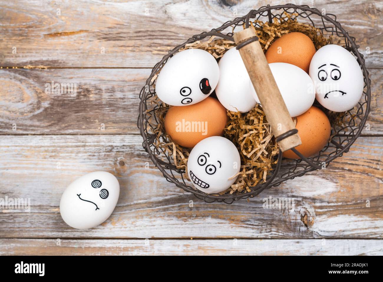 Legen Sie nicht alle Eier in einen Korbhintergrund. Lustige Eier mit verschiedenen Stimmungsgesichtern. Juli 9 - National Don't Put All Your Eggs in One Omelet Day Stockfoto