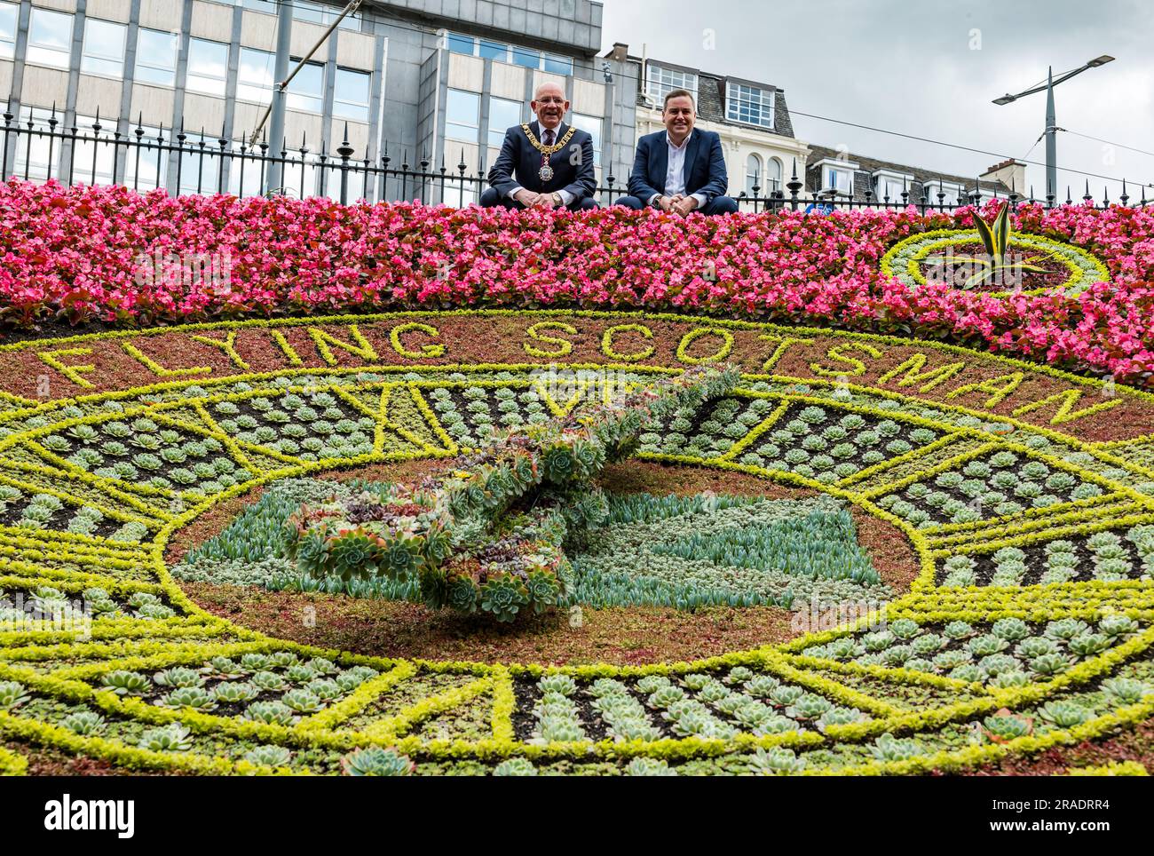 Princes Street Gardens, Edinburgh, Schottland, Großbritannien, 3. Juli 2023. Enthüllung der Blumenuhr zu Ehren von 100 Jahren fliegendem Schotten: Jedes Jahr feiert die berühmte Blumenuhr (seit 1903 blühend) ein anderes Ereignis und feiert dieses Jahr das hundertjährige Bestehen des Fliegenden Schotten. Bild (L bis R): Lord Provost Robert Aldridge & Andrew McLean (Nationalmuseum für Eisenbahnen). Kredit: Sally Anderson/Alamy Live News Stockfoto